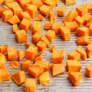 Chopped sweet potato pieces spread out on a baking tray.