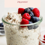 A glass jar brimming with cottage cheese overnight oats, crowned with blueberries and raspberries. Text above reads "Cottage Cheese Overnight Oats 24g protein!.