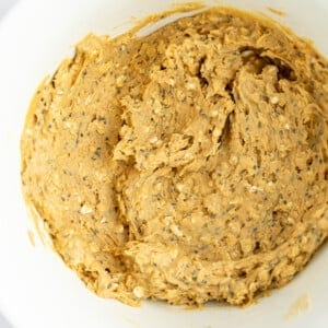 Creamy peanut butter and chia seed mixture in a white bowl, ready for baking or spreading.