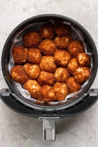 Golden brown breaded balls arranged in a circular air fryer basket.