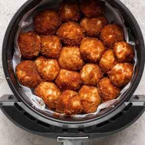 Golden brown breaded balls arranged in a circular air fryer basket.