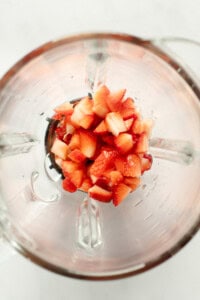 Diced strawberries inside a blender viewed from above.