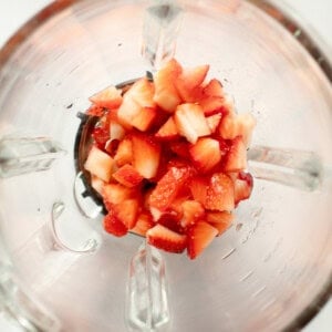 Diced strawberries inside a blender viewed from above.