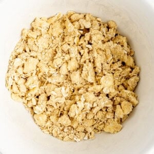 A bowl filled with a dry, crumbly mixture, likely a blend of oats, flour, and butter, commonly used for a crumble topping in baking.