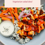 Buffalo Halloumi Salad with sliced carrots, cucumbers, red onions, blue cheese, and dressing on a round plate. Label reads "Vegetarian salad idea!".