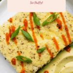A plate with a square piece of baked scrambled eggs topped with green onions and hot sauce, served with sliced avocado. Text overlay reads, "Baked Scrambled Eggs So fluffy!.