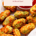 Golden-brown zucchini tots on parchment paper next to a bowl of ketchup; text overlay reads "Cheesy Zucchini Tots In the air fryer!.